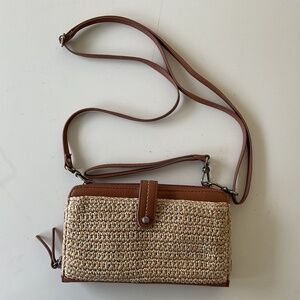 Brown leather cross body purse with beige woven trim on front.